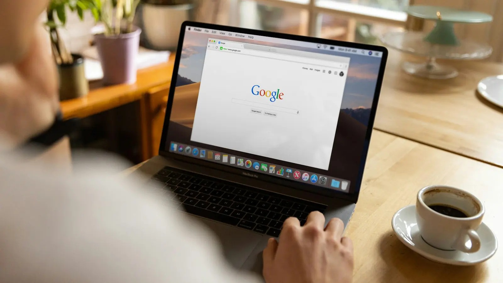 A laptop open on a search results page, beside a cup of coffee